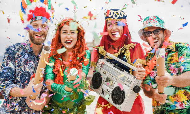 Gente vestida feliz celebrando en la fiesta de carnaval tirando confeti - Concéntrate en las manos de la chica izquierda